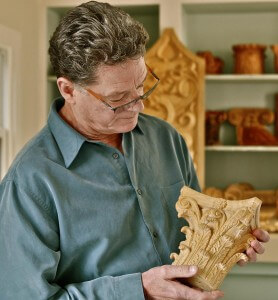 Ian Agrell holds a Corinthian capital hand-carved by Agrell Architectural Carving.