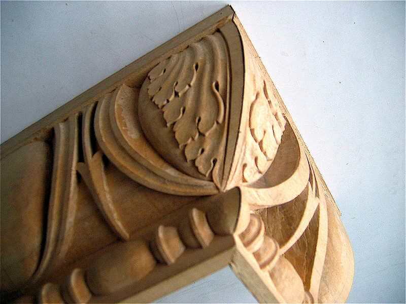 To avoid a messy clash of shapes, we typically carve an acanthus motif on the miters of our mouldings. Doing so also retains the profile of the moulding along the miter.